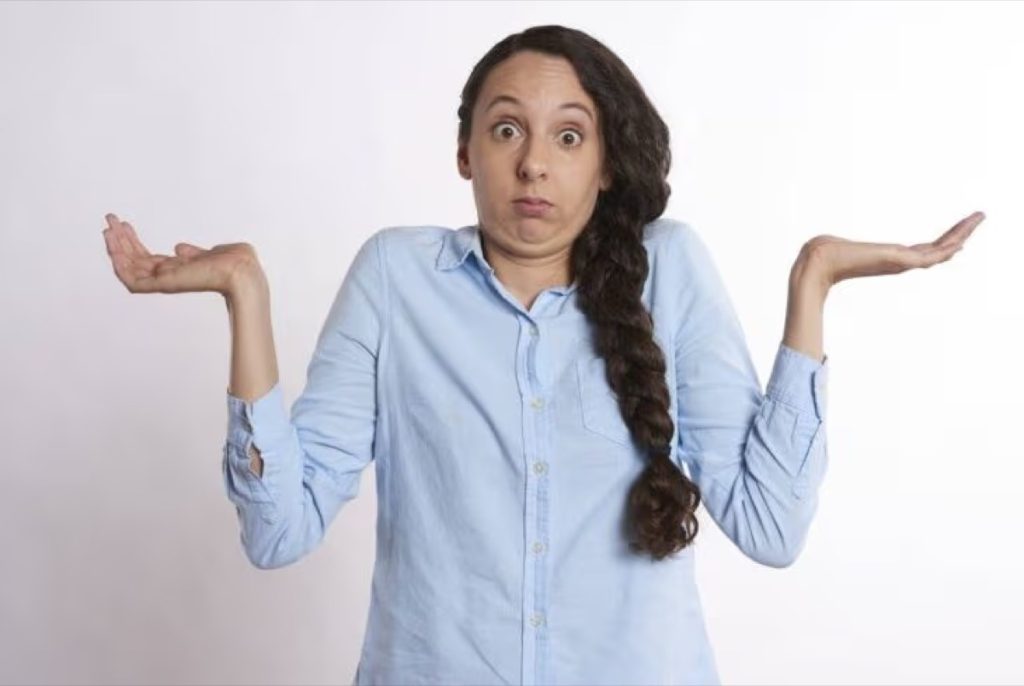 Woman shrugging with her palms turned up