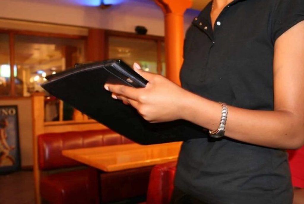 Restaurant server holding a black tablet menu