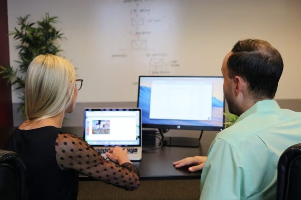 Two coworkers reviewing a website on a computer screen in an office